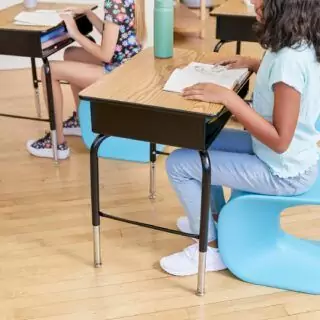 Adjustable classroom desk in oak finish featuring a metal storage compartment, designed to enhance school learning and organization.
