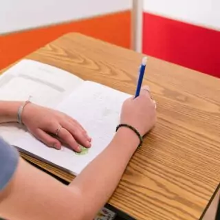 Adjustable ECR4Kids Classroom Desk in oak with metal storage, featuring a unique design ideal for versatile and organized learning spaces.