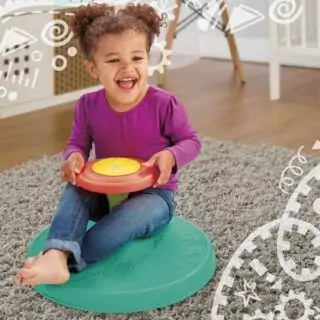 Toddler enjoying the Playskool Sit 'n Spin Classic Toy, perfect for developing motor skills and providing endless fun and active play.