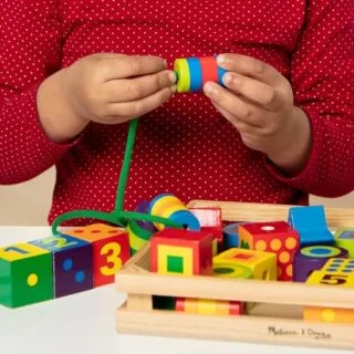 Engage in creative, educational play with the Melissa & Doug Wooden Lacing Beads Set, promoting fine motor skills and color recognition.